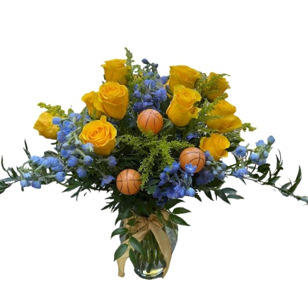 Yellow roses and blue flowers in a glass vase with small basketball picks