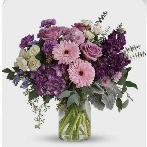 Pink and purple mixed bouquet in a clear glass vase