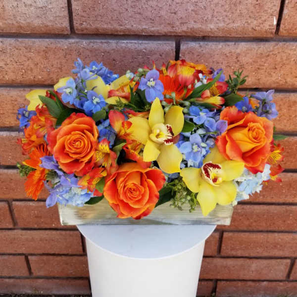 Bright mixed bouquet with orange roses, yellow orchids, and blue flowers