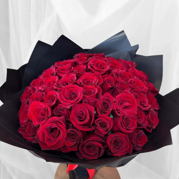 Bouquet of red roses wrapped in black paper