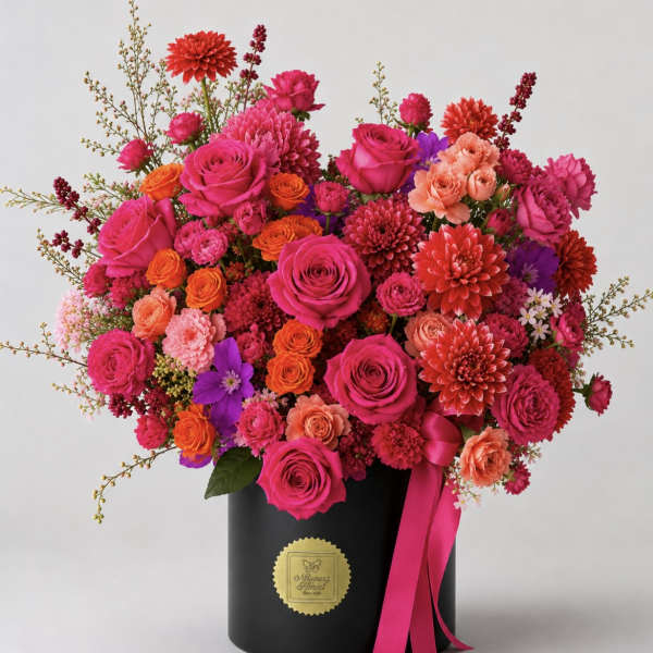 Bright mixed bouquet in a black hatbox with a pink ribbon