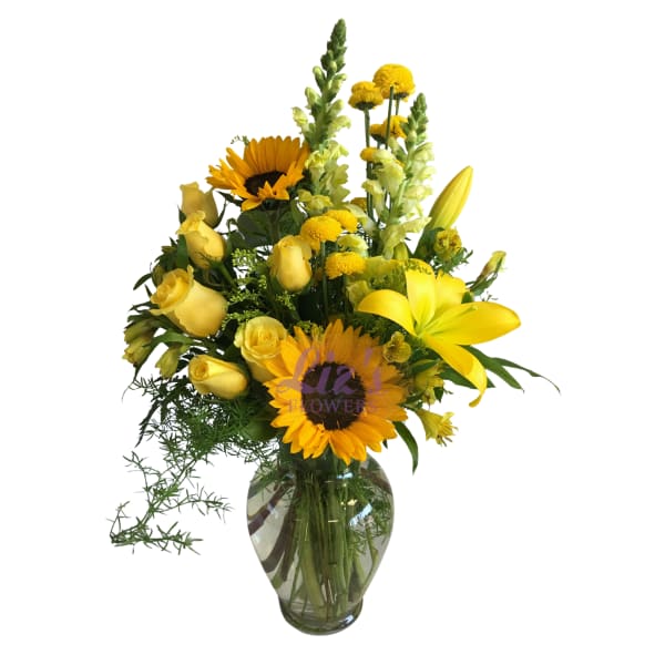 Yellow bouquet with sunflowers, roses, lilies, and snapdragons in a glass vase