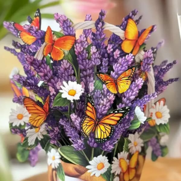 Purple flowers in a woven basket with butterfly decorations and white daisies
