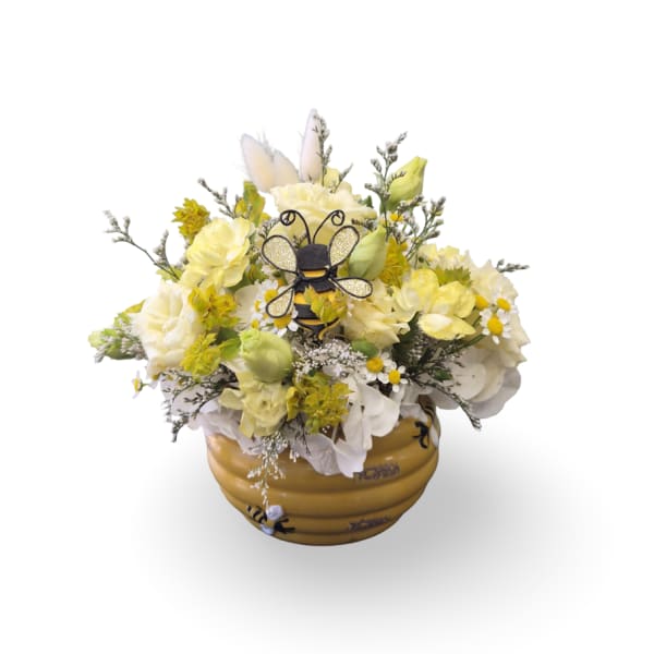 Yellow and white floral arrangement in a bee-themed pot