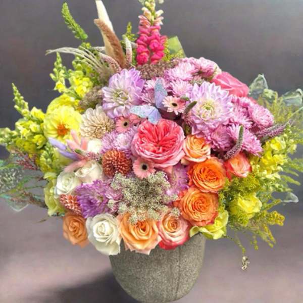 Colorful mixed flower arrangement in a gray vase
