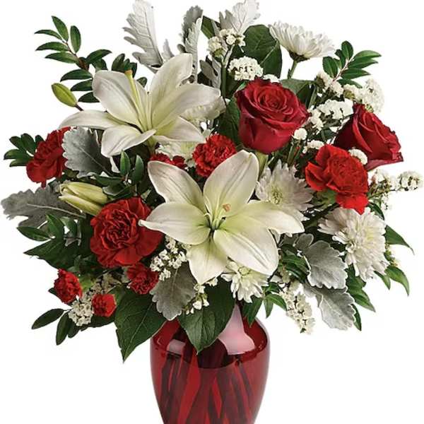 Red roses and white lilies in a red glass vase