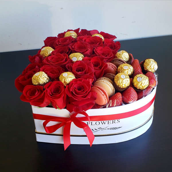 Heart-shaped box of red roses with chocolates and strawberries