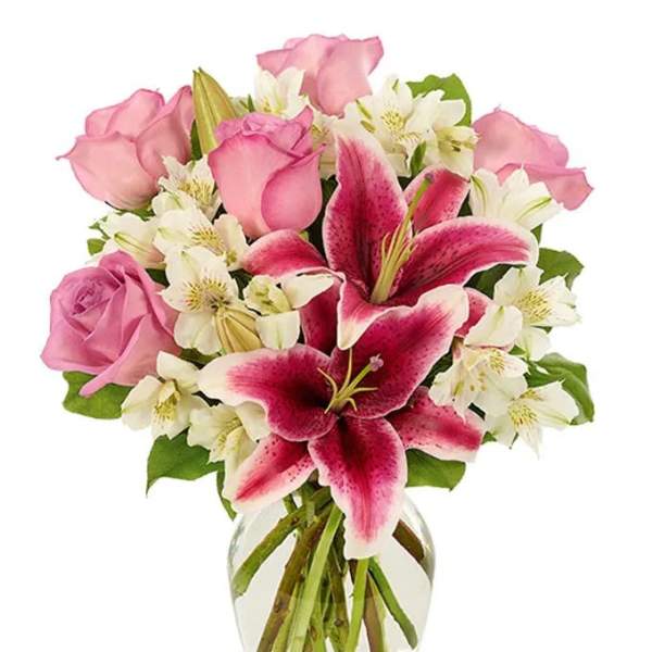 Pink roses and white lilies in a clear glass vase