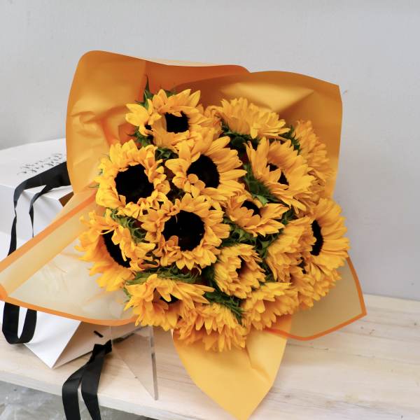 Bouquet of yellow sunflowers wrapped in orange paper