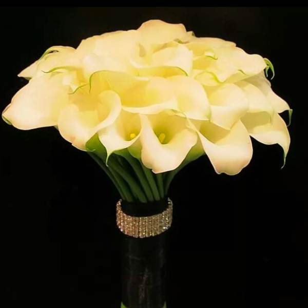 Bouquet of white calla lilies with a glittery band around the stems