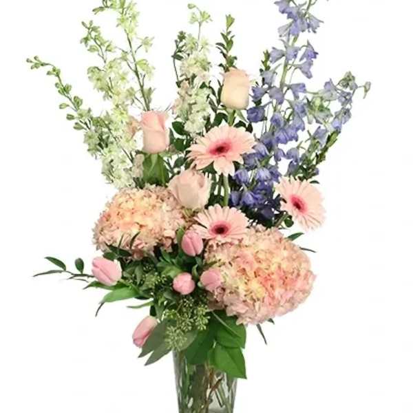 Pink and blue mixed flowers in a clear glass vase
