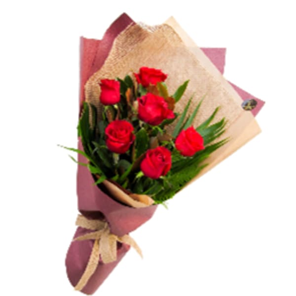 Bouquet of red roses wrapped in pink and tan paper