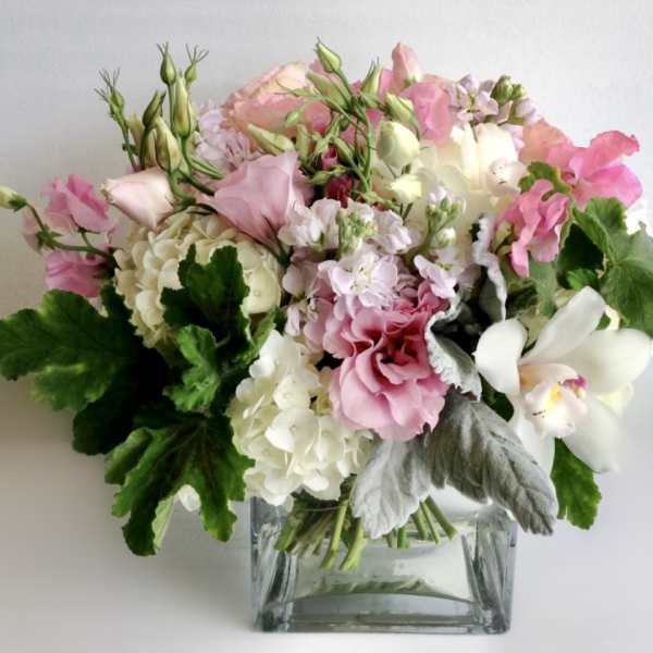 Pink and white mixed bouquet in a square glass vase