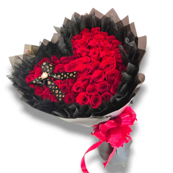 Bouquet of red roses wrapped in black paper with a pink ribbon