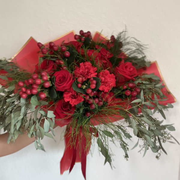 Bouquet of red roses and carnations with berries and greenery