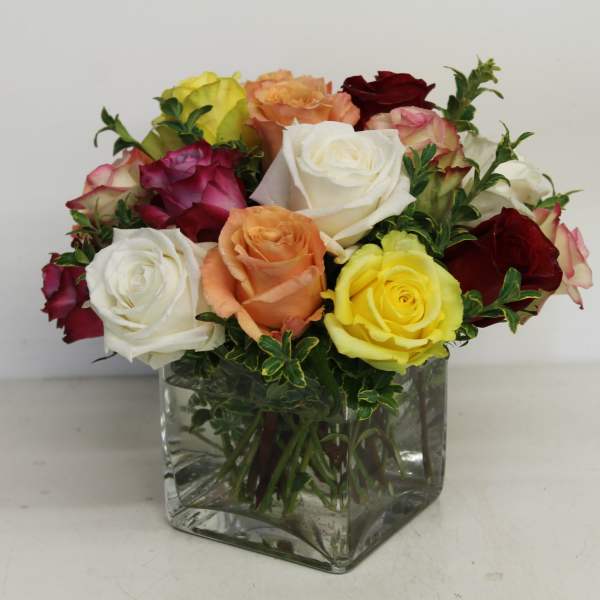 Mixed roses in a clear square glass vase