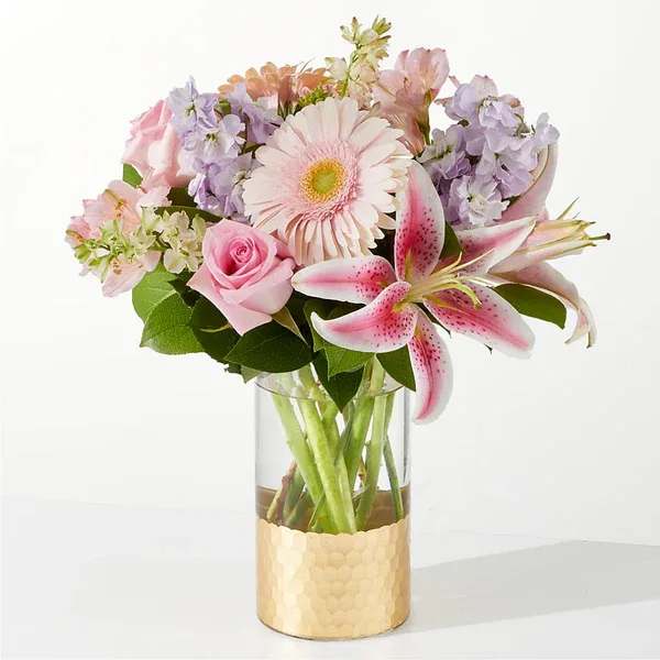 Pink and lavender bouquet in a clear glass vase with a gold base