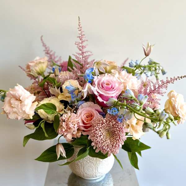 Pink and peach floral arrangement in a white vase