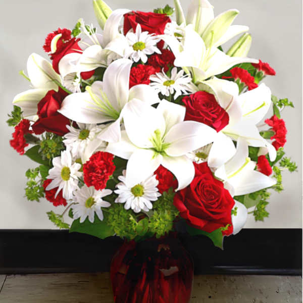 Bouquet of red roses, white lilies, and white daisies in a red vase