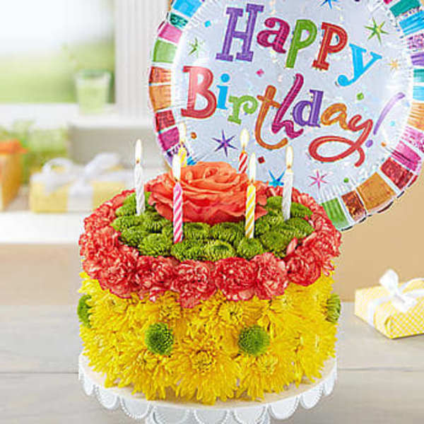 Flower cake with candles and a birthday balloon