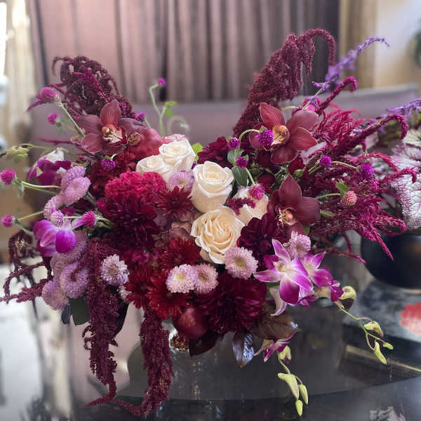 Bouquet of white roses and magenta orchids with burgundy blooms