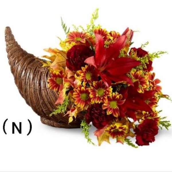 Cornucopia arrangement of red and yellow flowers in a woven horn basket