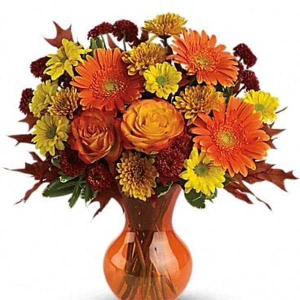 Orange and yellow mixed bouquet in an amber glass vase