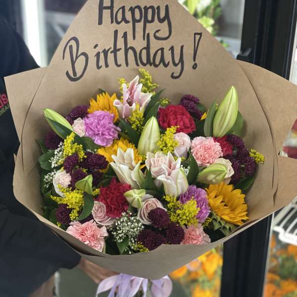 Mixed bouquet with a Happy Birthday sign and brown paper wrap