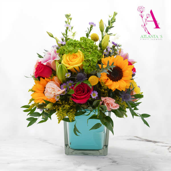 Colorful bouquet in a square glass vase with roses and sunflowers