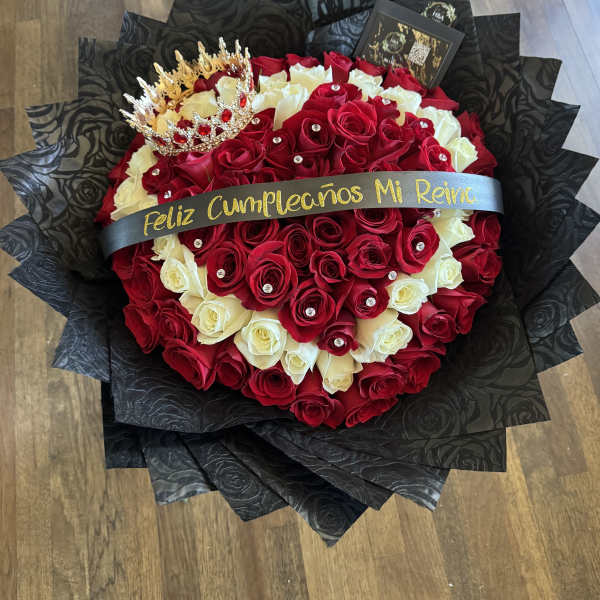 Heart-shaped bouquet of red and white roses with a crown topper
