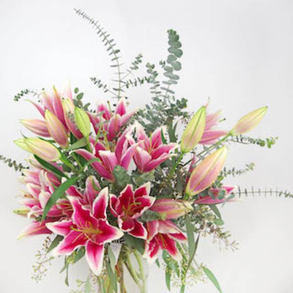 Bouquet of pink and white lilies with eucalyptus in a vase