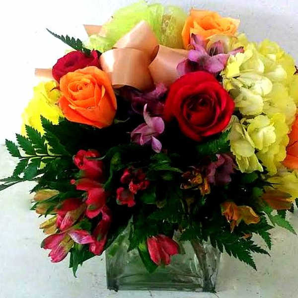 Mixed bouquet of roses and lilies in a clear glass vase