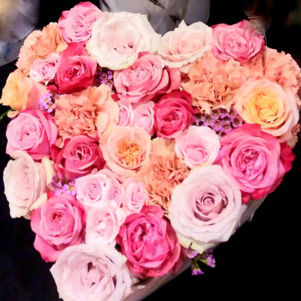 Heart-shaped bouquet of pink, white, and peach roses