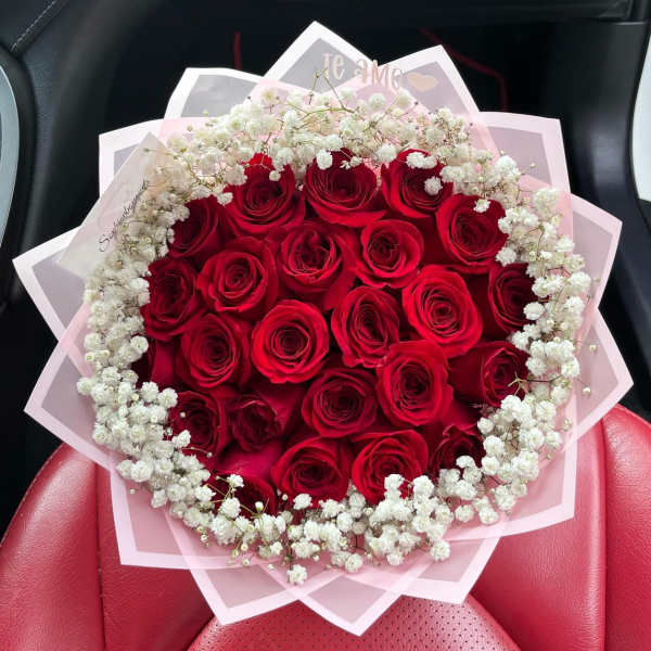 Bouquet of red roses with white baby's breath in pink wrapping