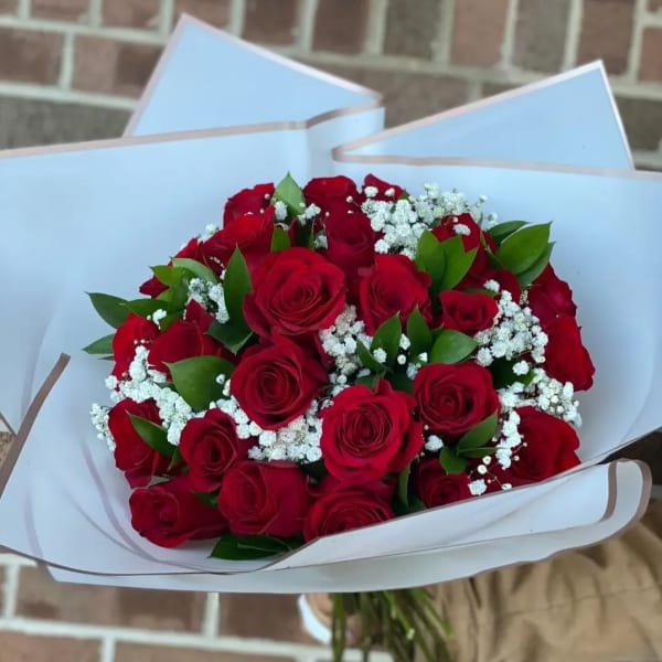 Bouquet of red roses with white baby's breath in white wrapping