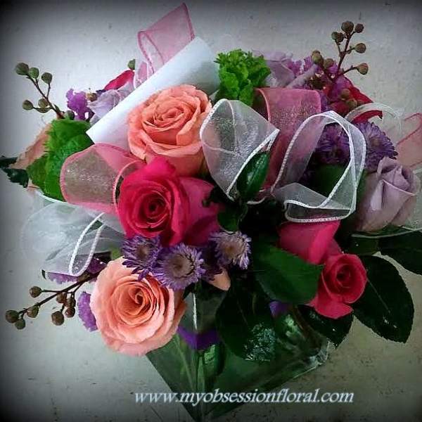 Bouquet of pink and peach roses with purple flowers and ribbon wrap
