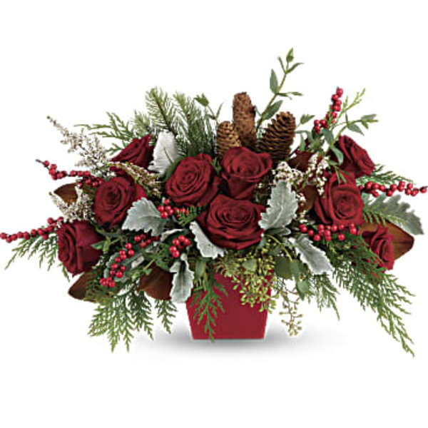 Red roses in a red container with pinecones and berries