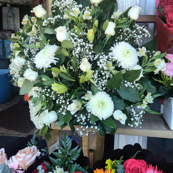 White floral arrangement with roses, lilies, and chrysanthemums