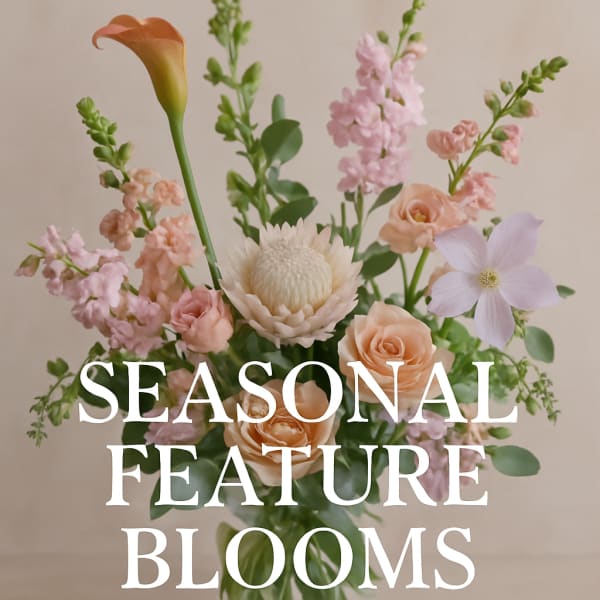 Pastel floral arrangement with peach roses, pink blooms, and a calla lily