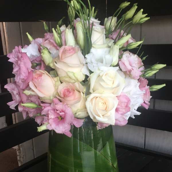 Pink and white roses with lisianthus in a glass vase