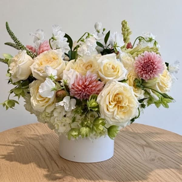 Cream and pink floral arrangement in a white vase