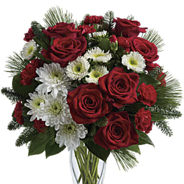 Red roses and white daisies in a clear glass vase