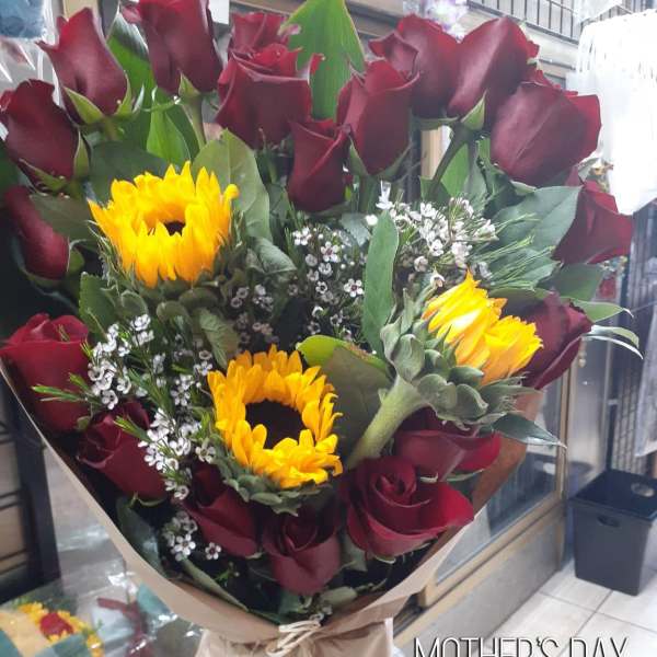 Bouquet of red roses and yellow sunflowers wrapped in brown paper
