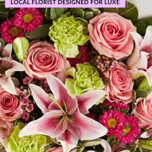 Pink roses and a pink lily with bright green carnations and magenta daisies
