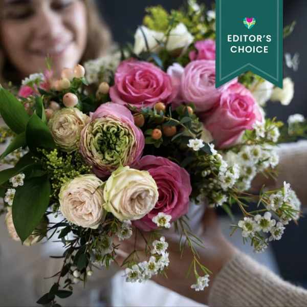 Bouquet of pink and cream roses with small white filler flowers