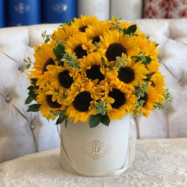 Bouquet of yellow sunflowers in a white hatbox