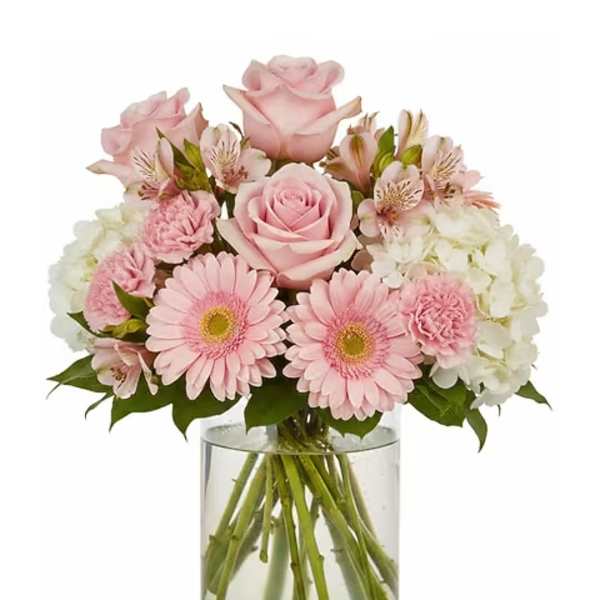 Pink roses and gerbera daisies in a clear glass vase