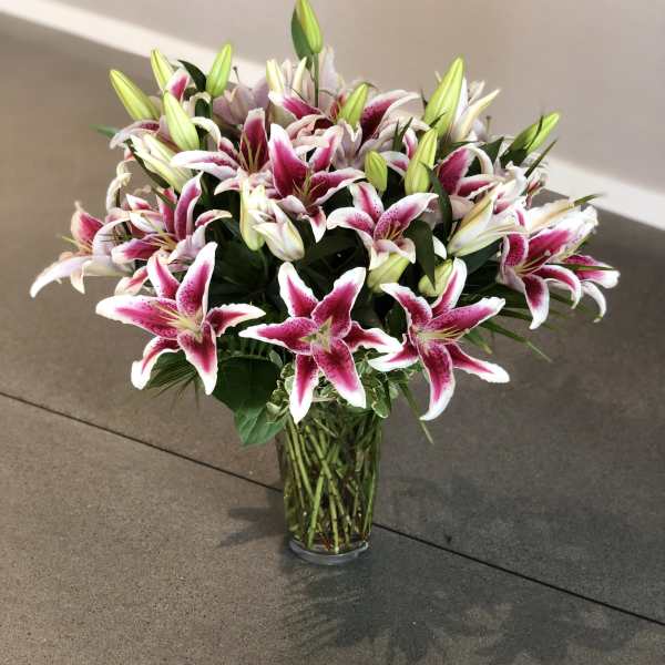 Bouquet of pink and white lilies in a clear glass vase