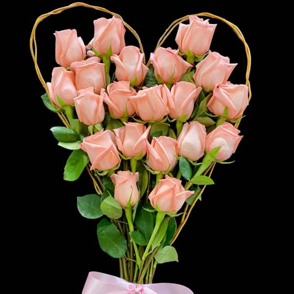 Pink roses arranged in a heart-shaped frame with a pink ribbon
