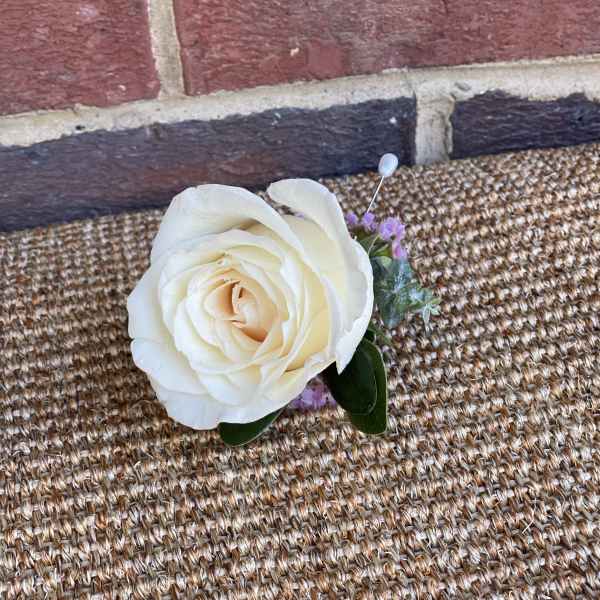Single cream rose boutonniere with small purple accents